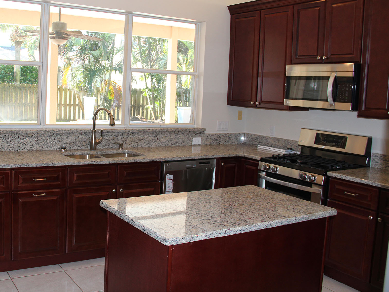 Redwood colored cabinets with white and black glassy colored countertops